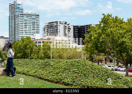 Homme avec parapluie à plus de St Kilda Rd de Kings Domain à Melbourne Banque D'Images