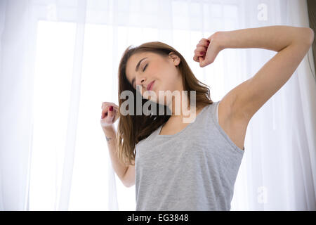 Young Beautiful woman stretching hands in matin Banque D'Images