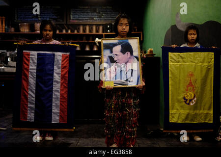 Jeune fille tenant une figure de de Bhumibol Adulyadej, Roi de Thaïlande, également connu sous le nom de Rama IX dans un restaurant dans le district de Dan Sai dans le nord de la province de Loei en Thaïlande Banque D'Images