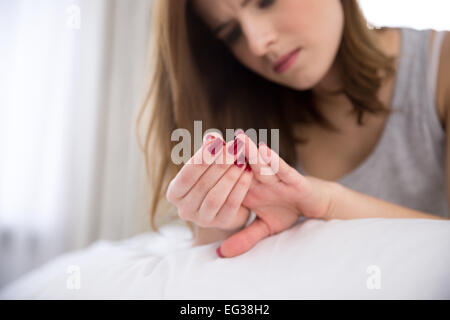 Jeune femme s'occupe d'ongles. Se concentrer sur les ongles Banque D'Images