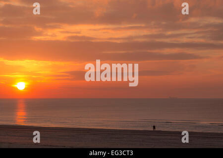 Un couple bénéficiant d'un romantique coucher de soleil sur la mer du Nord sur la St-Valentin à Katwijk aan Zee, Hollande méridionale, Pays-Bas. Banque D'Images