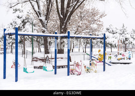 Jeux pour enfants dans un parc public couvertes de neige de l'hiver Banque D'Images