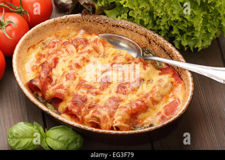 Les Cannelloni au four dans une rôtissoire sur un fond de bois Banque D'Images