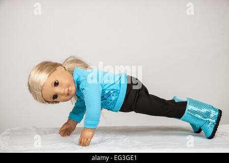 American Girl doll dans ses vêtements d'entraînement faisant push-ups Banque D'Images