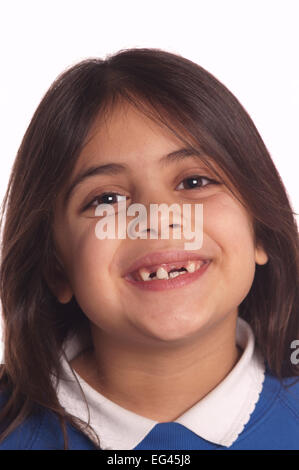 Sept ans fille heureuse en grandissant et fait sur le point de perdre leur robe dernière dent de devant les dents de lait ne tombent Banque D'Images