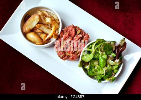 Steak tartare, pommes frites et salade verte Banque D'Images