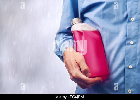Homme main tenant une bouteille d'antigel à base d'eau additif pour liquide froid hiver la conduite automobile. Banque D'Images