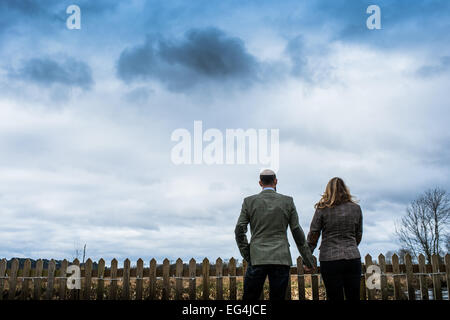 Silhouette aperçu de deux personnes se tenant la main à l'opposé de l'appareil photo avec un ciel atmosphérique Banque D'Images