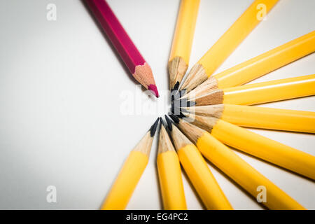 Un crayons rouge debout à partir d'un groupe de crayons de couleur jaune Banque D'Images