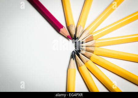 Un crayons rouge debout à partir d'un groupe de crayons de couleur jaune Banque D'Images