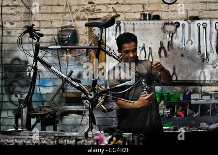 Un mécanicien cycliste assemble un vélo fait sur une petite échelle dans l'usine de vélos à Bogota, Colombie. Banque D'Images