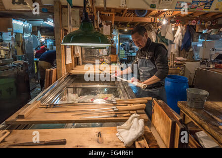 TOKYO, JAPON - 22 novembre, 2014 : Ancien homme japonais avec des couteaux à Tsukiji, le plus grand marché de poissons et de fruits de mer en t Banque D'Images