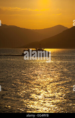 À la recherche sur le Firth of Clyde, en direction de l'Argyle hills au coucher du soleil avec silloeted bateau contre la lumière. Banque D'Images