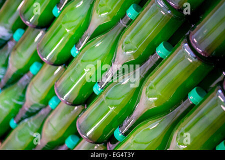 Les lignes diagonales de bouteilles en verre vert en embouteillage Banque D'Images