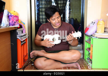 Thai man jouer Ukulele ou guitare acoustique petit Banque D'Images