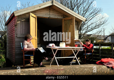 Un couple de détente à leur cabane de plage whistable UK Banque D'Images