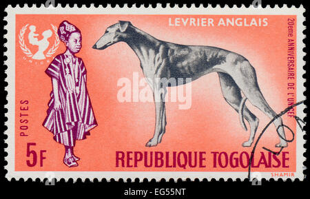 TOGO - circa 1967 : timbre imprimé par le Togo, présente le 20e anniversaire de l'UNICEF et chien lévrier Greyhound - Anglais, vers 1967 Banque D'Images