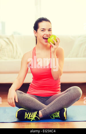 Smiling teenage Girl with Green Apple à la maison Banque D'Images