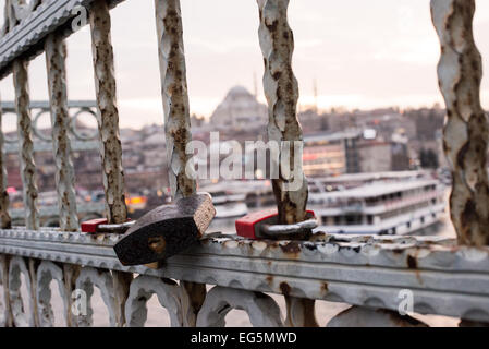 ISTANBUL, Turquie — en tant qu'invité d'amour que de nombreux touristes ont adopté dans le monde entier, des cadenas ont été laissés sur le pont de Galata à Istanbul. Enjambant la Corne d'Or et reliant Eminonu à Karakoy, le pont de Galata est un pont à deux niveaux qui gère la circulation routière, de tram et piétonne au niveau supérieur avec des restaurants et des bars au niveau inférieur. Au loin se trouve la mosquée Suleymaniye. Banque D'Images