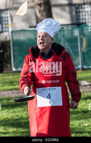 Londres, Royaume-Uni. 17 Février, 2015. Nigel Nelson, chroniqueur politique pour le Dimanche des gens pratiquant son pancake tossing technique avant le début de la course de crêpes parlementaire Rehab. Le concours annuel est parrainé par Harris Fowler, la blessure Procureurs et dispose de seigneurs, les députés et les membres du corps de presse parlementaire s'affrontent pour la course magnifique gobelet en étain. Credit : Gordon 1928/Alamy Live News Banque D'Images