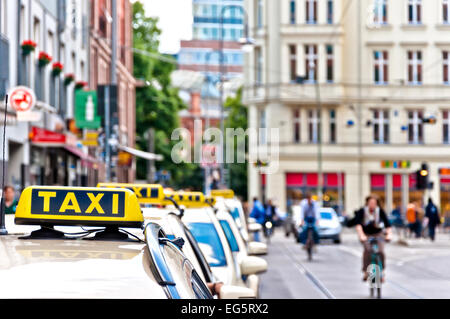 Rangée de taxis en attente avec le trafic et des vélos dans le quartier de Mitte à Berlin, Allemagne. Banque D'Images