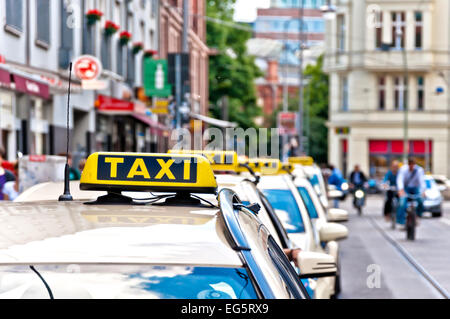 Rangée de taxis en attente avec le trafic et des vélos dans le quartier de Mitte à Berlin, Allemagne. Banque D'Images