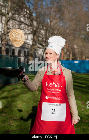 Sophie Ridge Sky news presenter, renverse une crêpe avant la course de crêpes parlementaire députés,2015. Banque D'Images