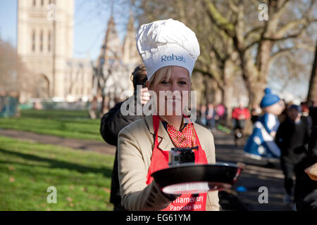 Sophie Ridge Sky news presenter, renverse une crêpe avant la course de crêpes parlementaire députés,2015. Banque D'Images