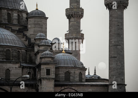 ISTANBUL, Turquie / Türkiye — le soleil couchant s'abaisse derrière une épaisse brume entre les minarets de la nouvelle Mosquée d'Istanbul. Banque D'Images