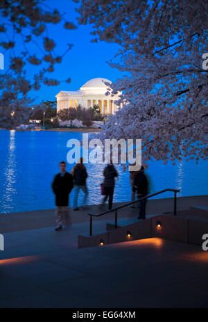 Le Jefferson Memorial sur le Tidal Basin au crépuscule avec les gens et les fleurs de cerisier qui se profile à l'avant-plan. Banque D'Images