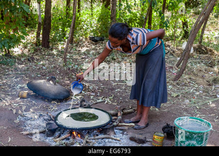 Une jeune femme faisant de l'injera (pain plat éthiopien), Lalibela, Éthiopie Banque D'Images