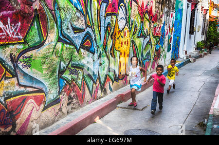 Cartagena, Colombie - Février 23, 2014 - Les enfants de courir à travers les rues colorées de Carthagène Getsemani neighbourhood. Banque D'Images