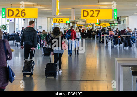 Les passagers à pied vers l'embarquement à l'aéroport de Schiphol, Amsterdam. Banque D'Images