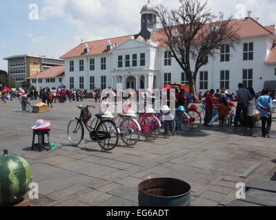 Une foule de jeunes prendre du repos au soleil sur la place en face de l'école. Banque D'Images