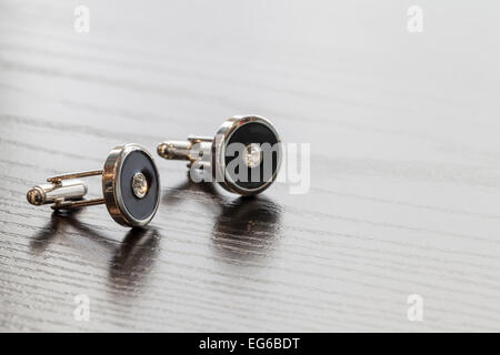 Argent cuff links sur table en bois close up Banque D'Images