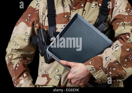 Close up image horizontale d'ordinateur portable avec des hommes armés alors qu'il la tenue de soldat sur fond noir. Banque D'Images