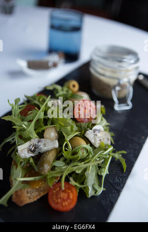 Canard en pot avec une salade d'Artichauts grillés, cornichons, tomates et roquette sauvage. Banque D'Images