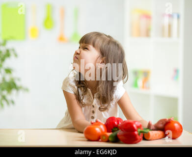 Kid girl avec expression de dégoût contre légumes Banque D'Images