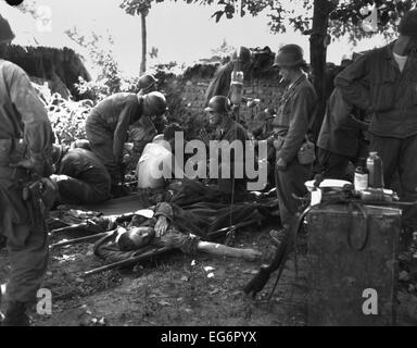 Des soldats américains reçoivent un traitement médical à un poste de premiers soins près de front de bataille de la Corée du Sud. Le 25 juillet 1950. Au cours de la bataille Banque D'Images