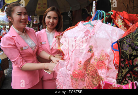 Un ado Thai essayez essayez de monter sur certains cheongsam de soie en préparation du Nouvel An chinois. © Vichan Poti/Pacific Press/Alamy Live News Banque D'Images