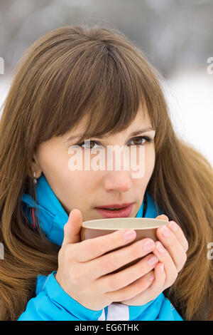 Young caucasian woman drinking hot café ou thé, à des activités de plein air hivernales. Jolie fille verre de dégustation Banque D'Images