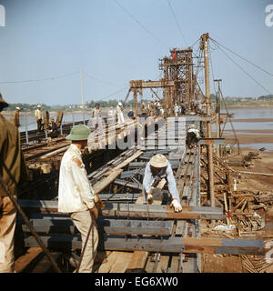 Un drapeau rouge avec des personnages coups sur la détruit le pont Long Bien, qui enjambe le fleuve Rouge à Hanoi avec une longueur de 1 683 mètres. Travailleurs commencent à reconstruire, photographié en mars 1973. Le pont de chemin de fer d'importance stratégique à partir du début du xxe siècle a été détruit à plusieurs reprises dans les raids aériens américains pendant la guerre du Vietnam. Les États-Unis d'Amérique a volé environ 2 000 attaques aériennes sur les villes et les cibles dans le nord du Vietnam au cours de l'explosif 'Noël' en 1972. L'accord de paix a été signé le 27 janvier en 1973 à Paris. Photo : Werner Schulze Banque D'Images