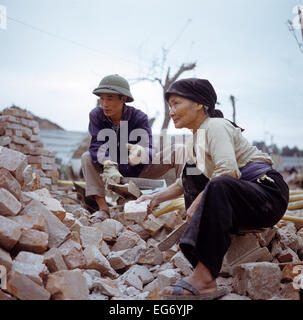 Un homme et une femme nettoyer briques réutilisables sur une étendue de gravats pour reconstruire les maisons détruites par la guerre dans la région du Kham Thien, une partie de Hanoi au Vietnam du Nord, photographié en mars 1973. Les États-Unis d'Amérique a volé environ 2 000 attaques aériennes sur les villes et les cibles dans le nord du Vietnam au cours de l'explosif 'Noël' en 1972. L'accord de paix a été signé le 27 janvier en 1973 à Paris. Photo : Werner Schulze Banque D'Images