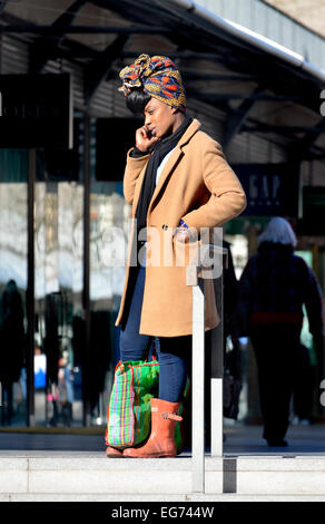 Londres, Angleterre, Royaume-Uni. Jeune femme noire avec un foulard coloré sur son téléphone portable, centre commercial du Nouveau-Brunswick, Bloomsbury Banque D'Images