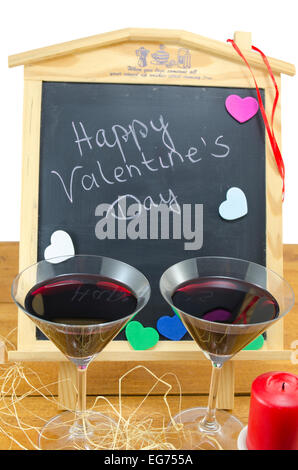 Tableau avec les mots Happy Valentines écrit dessus, décoré avec des coeurs et et deux verres Banque D'Images