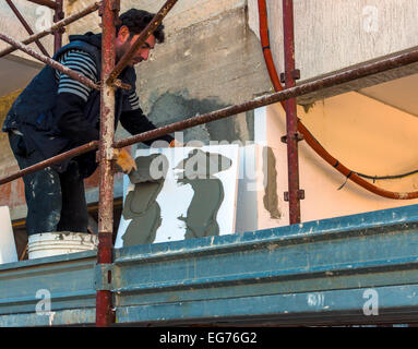 Les supports de travail feuilles de polystyrène sur les murs verticaux. Motion blure sur les outils et les tuiles. Banque D'Images