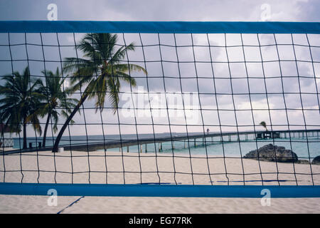 Maldives, Ari Atoll, vue mer avec trottoir de bois et filet de volley-ball dans l'avant-plan Banque D'Images