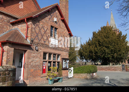 Village de Aldford, Angleterre. Vue pittoresque du village store avec St Jean Baptiste l'église de l'arrière-plan. Banque D'Images