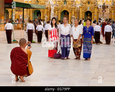 Un moine bouddhiste en prenant une photo de famille sur son téléphone mobile, Shwedagon Pagoda, Yangon, Myanmar, en Asie Banque D'Images