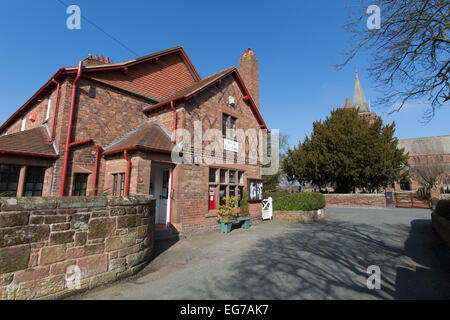 Village de Aldford, Angleterre. Vue pittoresque du village store avec St Jean Baptiste l'église de l'arrière-plan. Banque D'Images